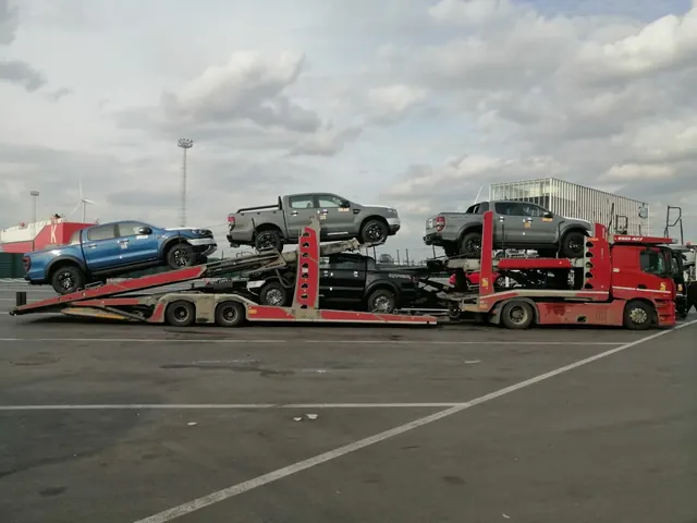 Platformă auto încărcată cu pickup și autoturisme, în parcare industrială