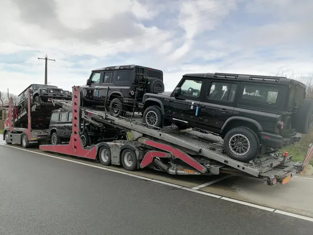 Platformă auto Romfour transportând două SUV-uri de teren negre