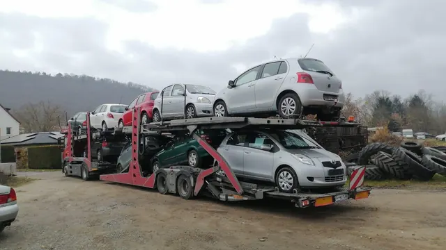 Platformă auto cu hatchback-uri argintii, în curte de depozitare